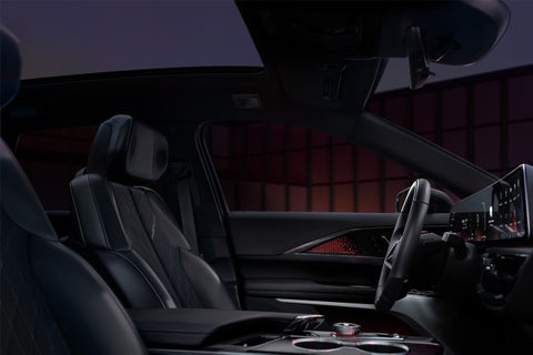 A Woman Activates the Dual Glass Power Sunroof of a 2025 Cadillac XT4 in the City