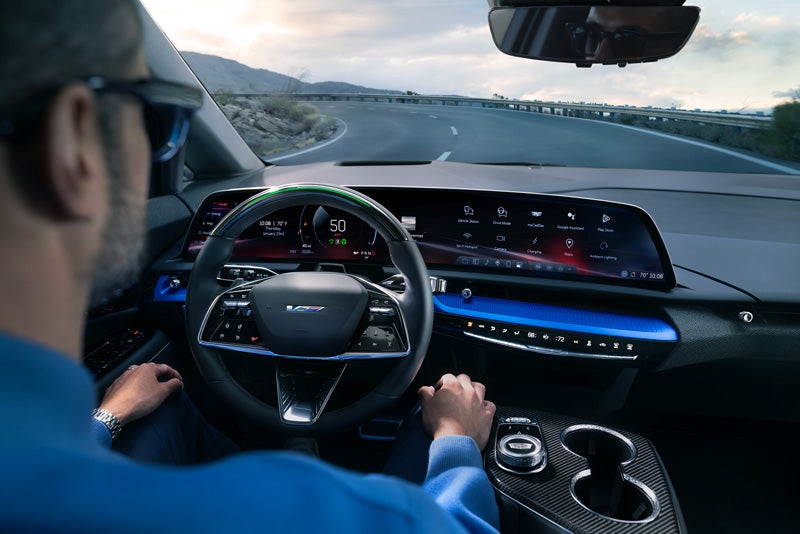 Front View of the 2026 OPTIQ-V Driving Through the Dusk Utilizing its Headlights | Denny Menholt Cadillac in Rapid City SD